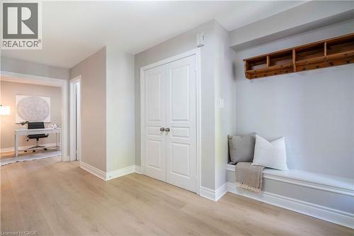 Entryway featuring light wood-finish flooring, a built-in bench with trim detail, a wooden coat rack, white double doors, and a recessed ceiling - 2425 Nichols Drive, Oakville, ON - Indoor Photo Showing Other Room
