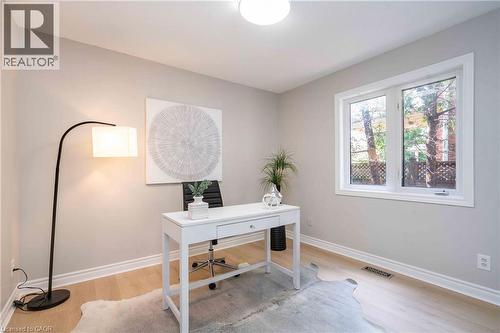 Bright room featuring light wood-finish flooring, a contemporary ceiling light fixture, and a large window with white trim - 2425 Nichols Drive, Oakville, ON - Indoor Photo Showing Office