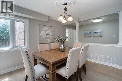Dining area featuring a wood-finish table, upholstered chairs with nailhead trim, and light wood-finish flooring - 2425 Nichols Drive, Oakville, ON - Indoor Photo Showing Dining Room