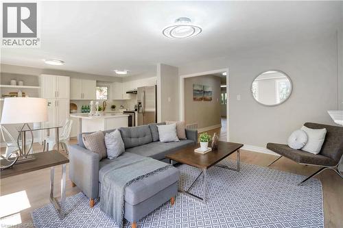 Light-toned wood-finish flooring extends throughout this living area, featuring recessed lighting and a contemporary ceiling fixture - 2425 Nichols Drive, Oakville, ON - Indoor Photo Showing Living Room