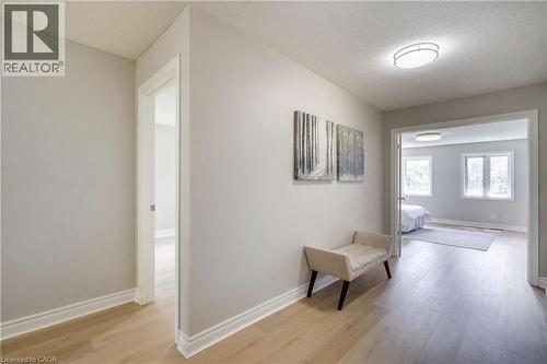 Light wood-finish flooring extending through the hallway and into a bright room - 2425 Nichols Drive, Oakville, ON - Indoor Photo Showing Other Room