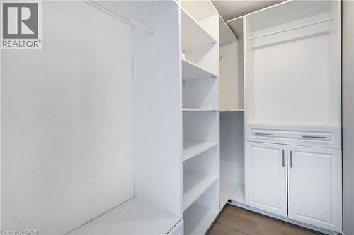 Custom white closet system featuring multiple shelving units, hanging rods, and lower cabinetry with drawers and doors - 2425 Nichols Drive, Oakville, ON - Indoor With Storage