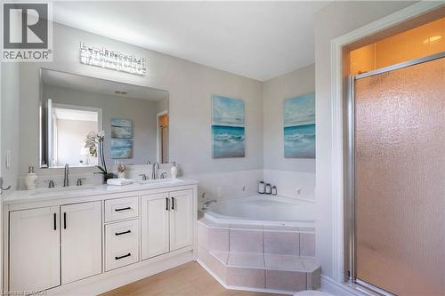 Dual vanity with white cabinetry, a large mirror, and a contemporary light fixture - 2425 Nichols Drive, Oakville, ON - Indoor Photo Showing Bathroom