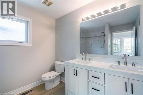Bathroom featuring a double vanity with white cabinetry, dual sinks, and brushed nickel fixtures - 2425 Nichols Drive, Oakville, ON - Indoor Photo Showing Bathroom