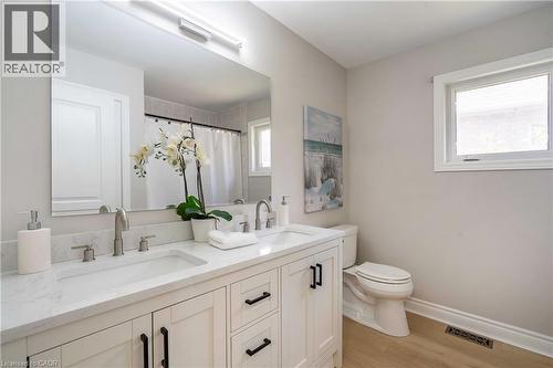 Bathroom featuring a double vanity with integrated rectangular sinks, white cabinetry, and brushed nickel fixtures - 2425 Nichols Drive, Oakville, ON - Indoor Photo Showing Bathroom