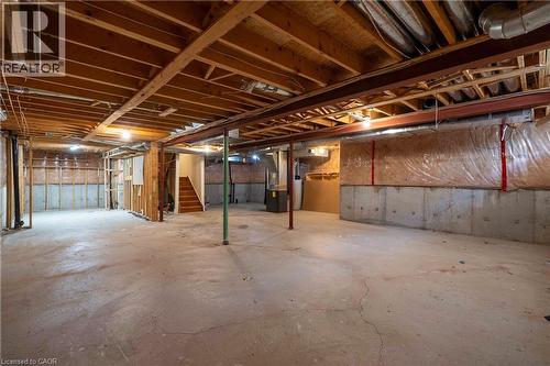 Unfinished basement featuring exposed wood joists, concrete flooring, concrete block foundation walls, and visible insulation - 2425 Nichols Drive, Oakville, ON - Indoor Photo Showing Basement