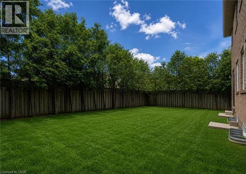 Expansive grass lawn bordered by a wood fence and mature trees - 2425 Nichols Drive, Oakville, ON - Outdoor