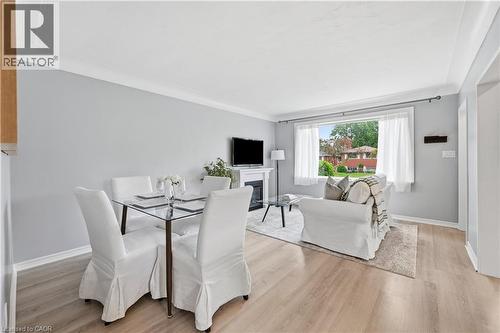 Open-concept living space featuring wood-finish flooring, a white trim package, and light gray walls - 189 Foxbar Road, Burlington, ON 