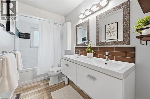 Contemporary bathroom featuring a white double vanity with integrated sinks and chrome fixtures - 189 Foxbar Road, Burlington, ON 