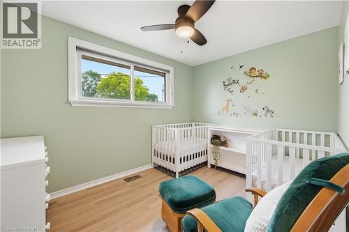 Room featuring a window with white trim, wood-finish flooring, and light green walls - 189 Foxbar Road, Burlington, ON 