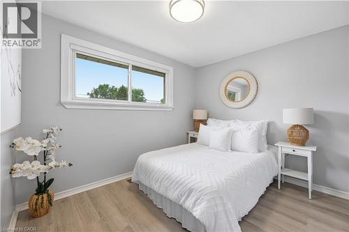 Bright interior space featuring light wood-finish flooring, a contemporary flush mount ceiling light, and a horizontal sliding window with white trim - 189 Foxbar Road, Burlington, ON 