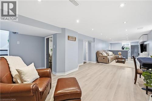 Spacious lower-level living area with light-toned wood-finish flooring, recessed lighting, and light blue walls - 189 Foxbar Road, Burlington, ON 