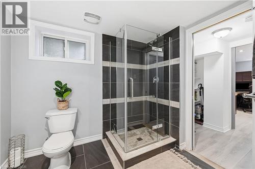 Glass-enclosed shower with dark and light striped tile surround - 189 Foxbar Road, Burlington, ON 