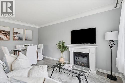 Living area featuring a white mantel, an integrated fireplace, and wood-finish flooring - 189 Foxbar Road, Burlington, ON 