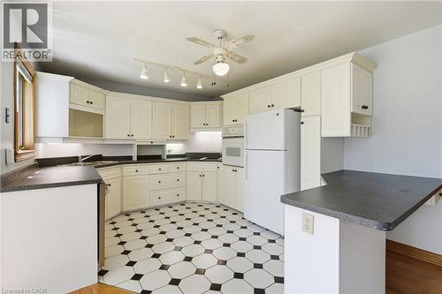 Spacious kitchen featuring extensive cream-colored cabinetry, dark countertops, and a striking black and white hexagonal tile floor - 3 Ancaster Street E, Dundas, ON - Indoor Photo Showing Kitchen