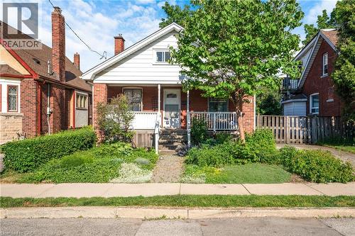 Brick and white siding exterior with a covered front porch featuring white railings - 295 Keswick Court, Hamilton, ON 