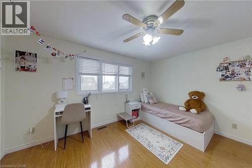 Light-filled room featuring wood-finish flooring, a multi-pane window with blinds, and a ceiling fan with integrated lighting - 233 Benesfort Crescent, Kitchener, ON 