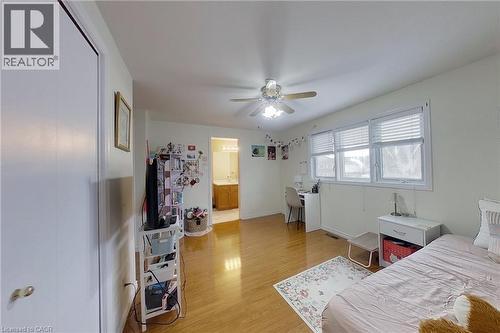 Spacious bedroom featuring wood-finish flooring and a ceiling fan with integrated lighting - 233 Benesfort Crescent, Kitchener, ON 