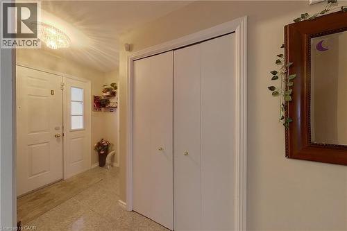 Entryway featuring light-toned flooring, white double doors with window inserts, and a flush-mount crystal light fixture - 233 Benesfort Crescent, Kitchener, ON 