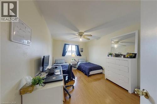 Bright bedroom featuring wood-finish flooring, a ceiling fan with integrated lighting, and a white framed window - 233 Benesfort Crescent, Kitchener, ON 