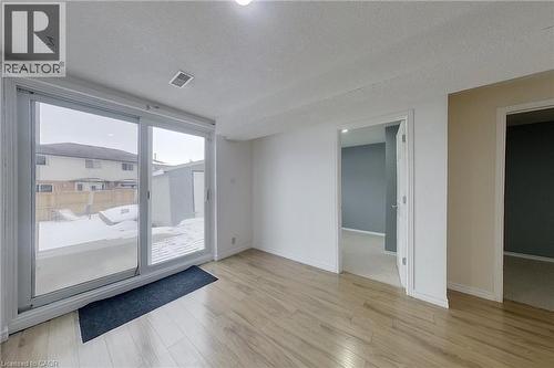 Interior space featuring wood-finish flooring, white painted walls, and a recessed ceiling light - 233 Benesfort Crescent, Kitchener, ON 