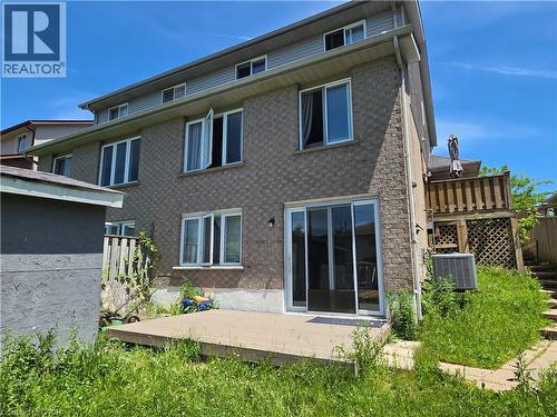 Brick exterior featuring multiple windows and a sliding glass door - 233 Benesfort Crescent, Kitchener, ON 