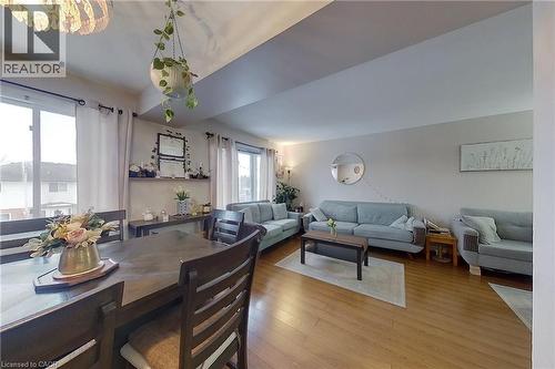 Open concept living and dining area featuring wood-finish flooring, recessed lighting, expansive windows, and a built-in floating shelf - 233 Benesfort Crescent, Kitchener, ON 
