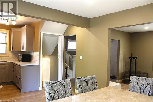 Open-concept living area featuring a kitchen with light grey cabinetry, white subway tile backsplash, and light-tone countertops - 4935 Willmott Street, Niagara Falls, ON 