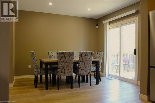 Dining area with wood-finish flooring, recessed lighting, and a sliding glass door providing access to an exterior deck - 4935 Willmott Street, Niagara Falls, ON 