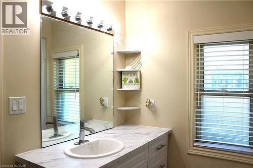 Bathroom vanity featuring a white oval sink, chrome faucet, and a marbled countertop - 4935 Willmott Street, Niagara Falls, ON 