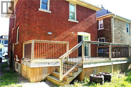 Spacious rear deck crafted from wood, featuring black vertical balusters and a staircase providing direct yard access - 4935 Willmott Street, Niagara Falls, ON 