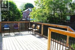 Outdoor wooden deck with plank flooring, wood railing, and dark vertical balusters - 