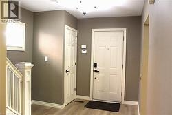 Entry foyer featuring light wood-finish flooring, neutral-toned walls, and white trim - 