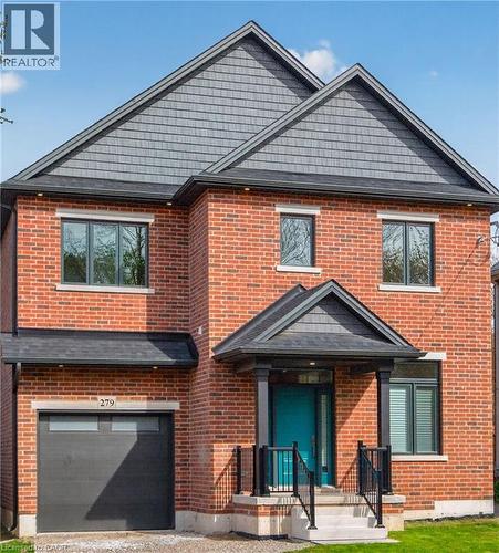 Brick facade featuring dark gray siding accents and a contrasting teal front door - 279 Hess Street S, Hamilton, ON - Outdoor With Exterior