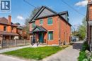 Contemporary brick exterior featuring a multi-level roofline, prominent front porch with black railings, and an integrated single-car garage - 279 Hess Street S, Hamilton, ON  - Outdoor 