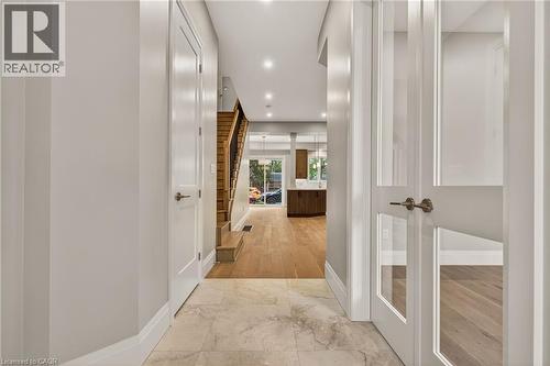 Foyer featuring large format natural stone tile flooring, recessed lighting, and a modern wood staircase with black iron balusters - 279 Hess Street S, Hamilton, ON - Indoor Photo Showing Other Room