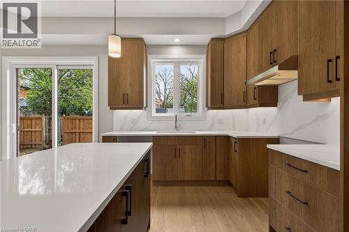 Kitchen featuring wood-finish cabinetry, white countertops, and a white tile backsplash - 279 Hess Street S, Hamilton, ON - Indoor Photo Showing Kitchen
