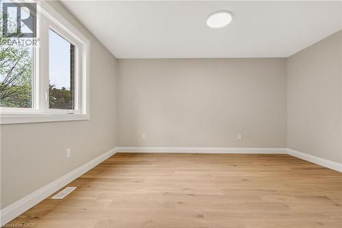 Bright room featuring wood-finish flooring, neutral wall tones, and crisp white trim - 279 Hess Street S, Hamilton, ON - Indoor Photo Showing Other Room