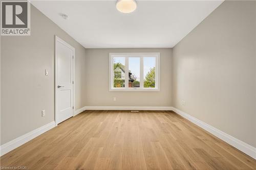 Spacious room featuring light wood-finish flooring, neutral wall paint, and white baseboards - 279 Hess Street S, Hamilton, ON - Indoor Photo Showing Other Room