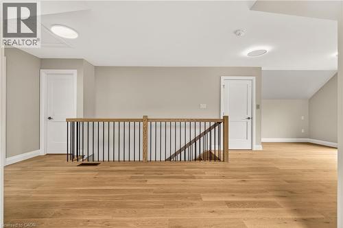 Hardwood flooring spans this upper level, featuring a contemporary wood and metal railing - 279 Hess Street S, Hamilton, ON - Indoor Photo Showing Other Room