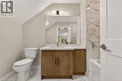 Bathroom featuring a wood-finish vanity with a white countertop, undermount sink, and large wall-mounted mirror - 279 Hess Street S, Hamilton, ON - Indoor Photo Showing Bathroom