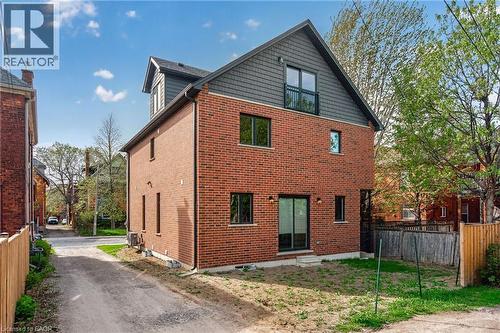 Brick exterior with dark gray siding and a black shingle roof - 279 Hess Street S, Hamilton, ON - Outdoor With Exterior