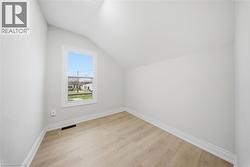 Room featuring light wood-finish flooring, white baseboards, and neutral wall paint - 