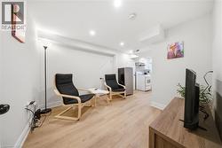 Open-concept living area featuring wood-finish flooring, recessed lighting, and white baseboards - 