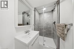 Compact bathroom featuring a white vanity with integrated sink, chrome faucet, and a wall-mounted mirror - 