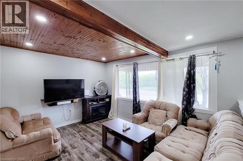 Living space featuring a wood-panel ceiling with recessed lighting, light-toned wall paint, and wood-finish flooring - 463 Wellington Street N, Hamilton, ON - Indoor Photo Showing Living Room