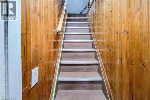Staircase with wood paneling, featuring a light wood handrail, painted treads, and light-colored risers - 463 Wellington Street N, Hamilton, ON - Indoor Photo Showing Other Room
