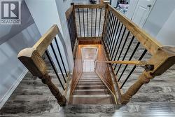 Staircase featuring wood newel posts, wood handrails, and black metal balusters - 