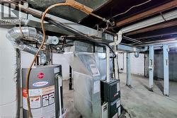 Mechanical room featuring a water heater, furnace, and exposed ductwork - 