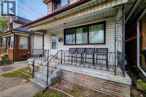Front porch featuring decorative wrought iron railing and concrete steps - 463 Wellington Street N, Hamilton, ON - Outdoor